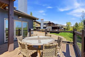 Spacious outdoor deck featuring wood-finish flooring and a rustic wood railing with wire mesh infill
