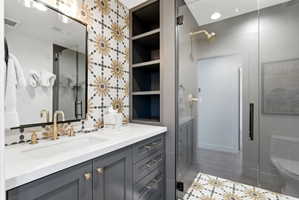 Bathroom vanity featuring a single rectangular undermount sink, brass-finish faucet, and a white countertop