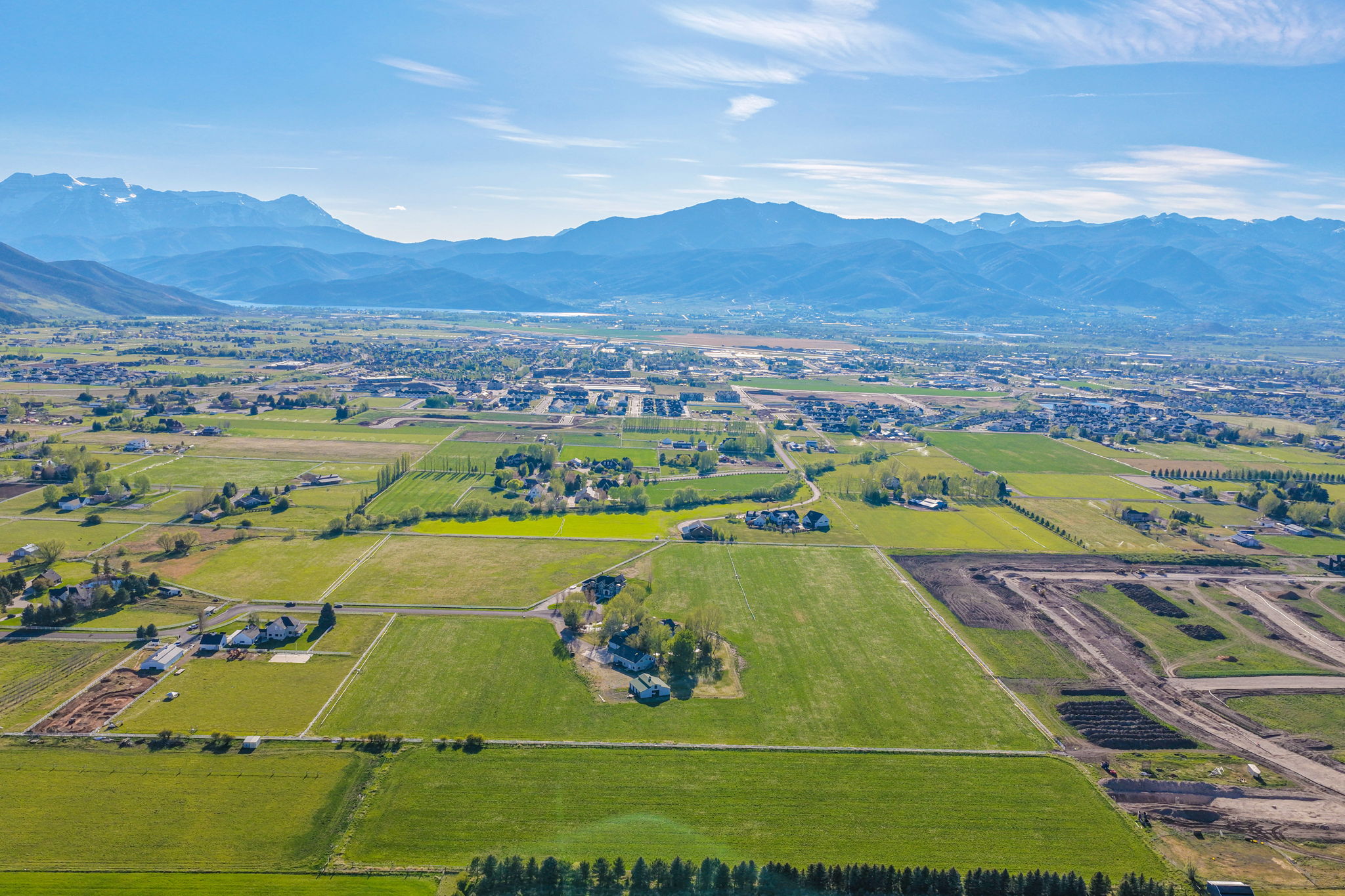 Expansive aerial panorama showcasing a valley landscape with distant mountains under a clear sky
