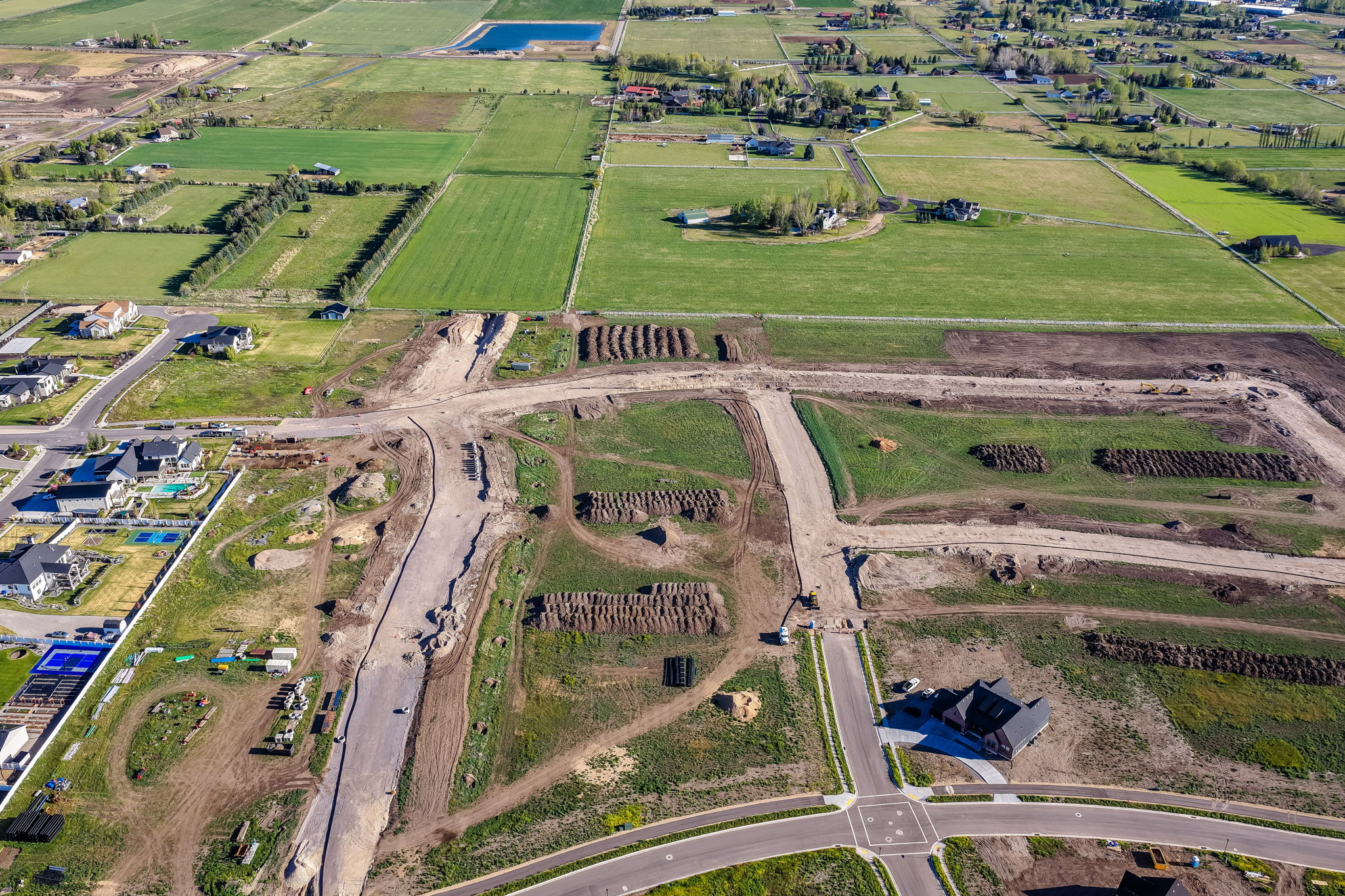 Aerial perspective showcasing undeveloped land parcels surrounded by paved roadways and existing residential structures
