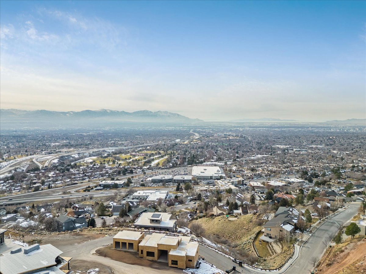 Expansive aerial perspective showcasing a broad urban landscape with distant mountains