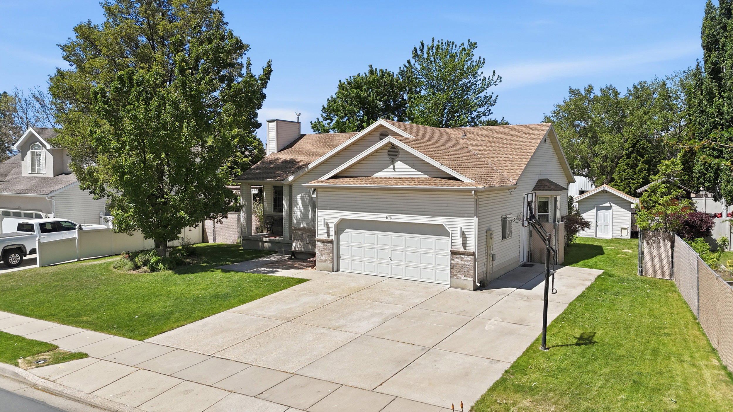 Single-story residence featuring a two-car garage and basketball hoop