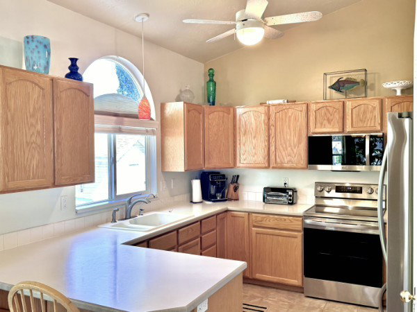 Kitchen featuring all new stainless steel appliances and a vaulted ceiling with a ceiling fan