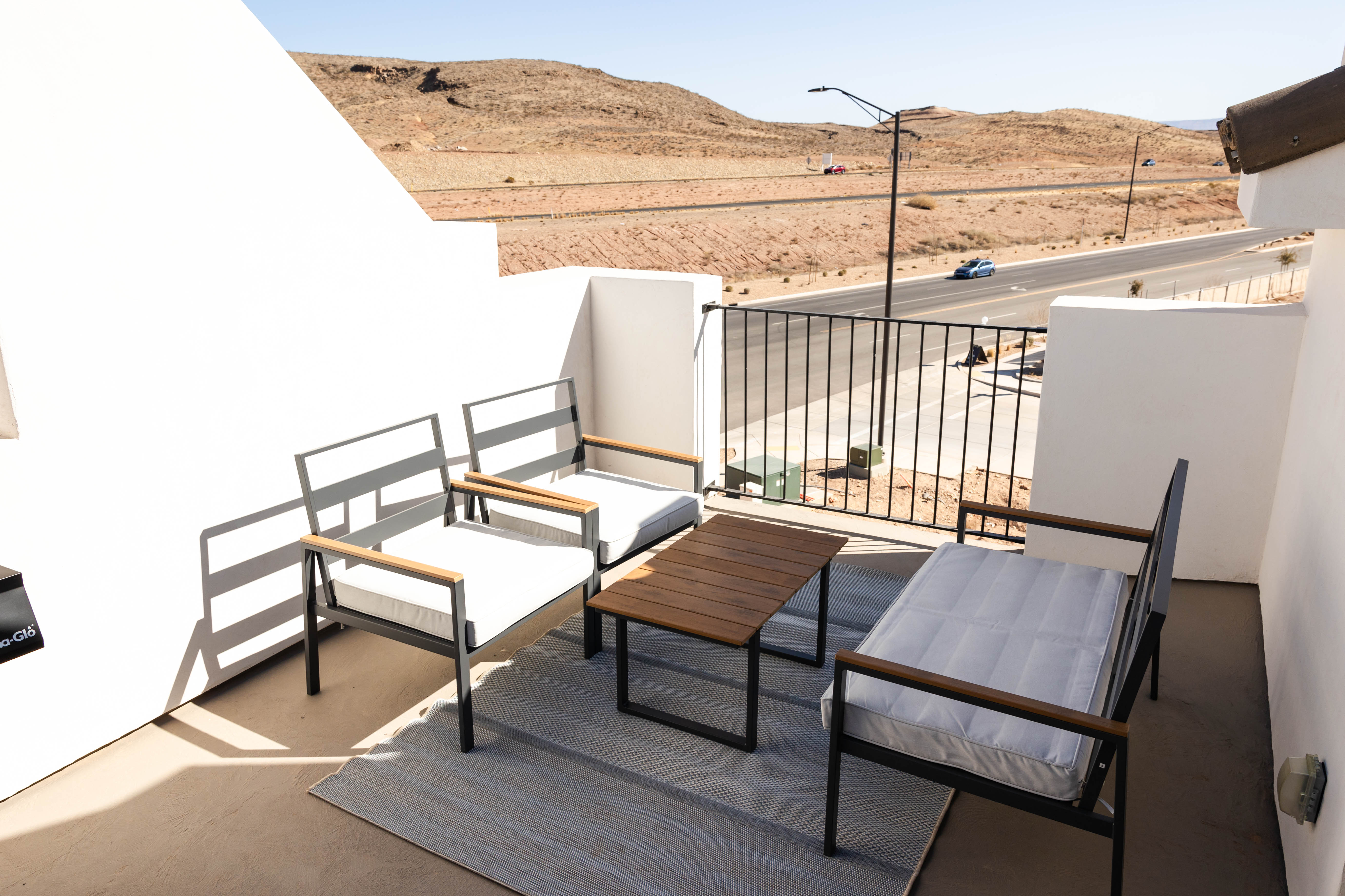 Outdoor patio featuring concrete flooring, a black metal railing, and a desert landscape backdrop