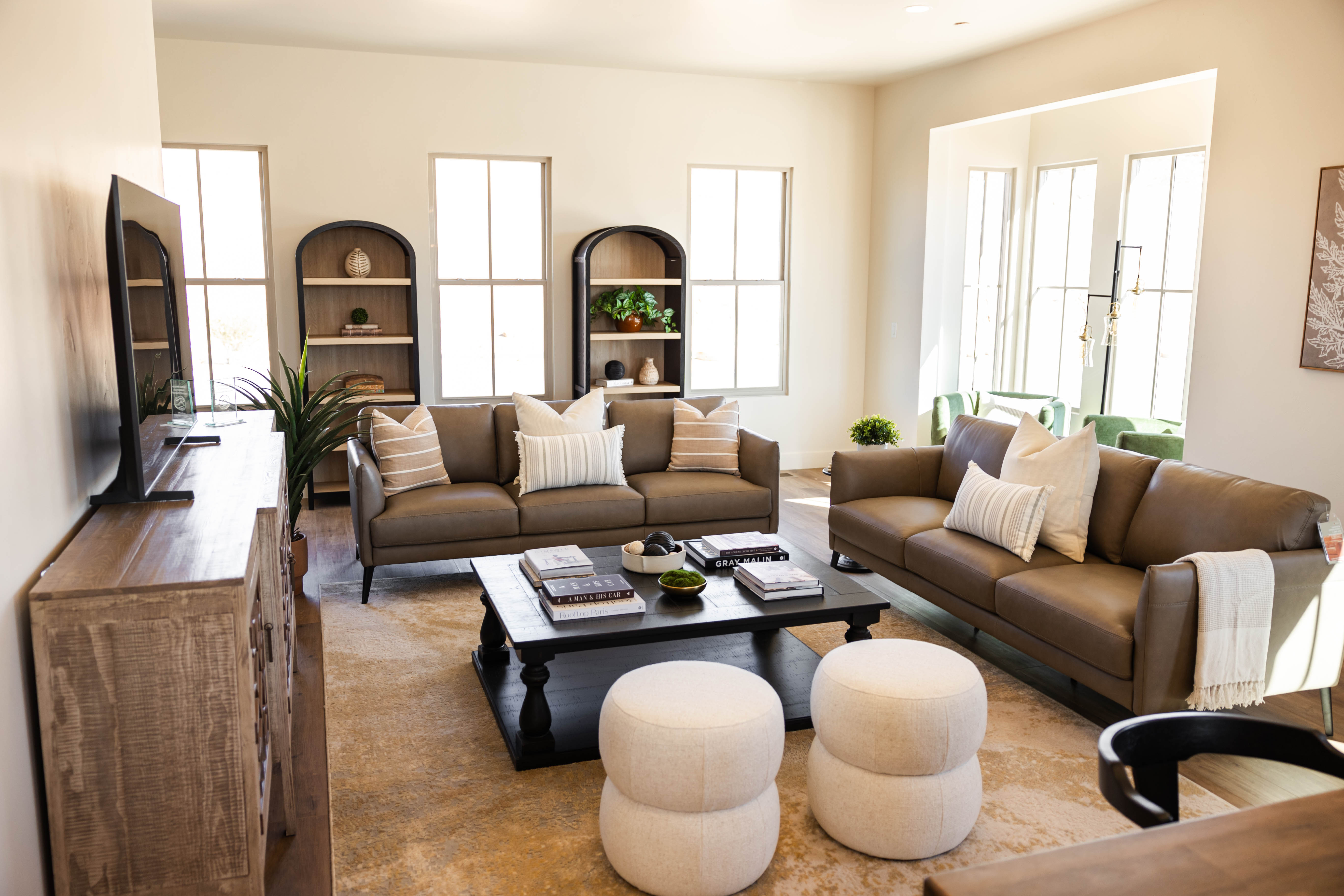 Spacious living area featuring high ceilings, multiple large windows, recessed lighting, and wood-finish flooring