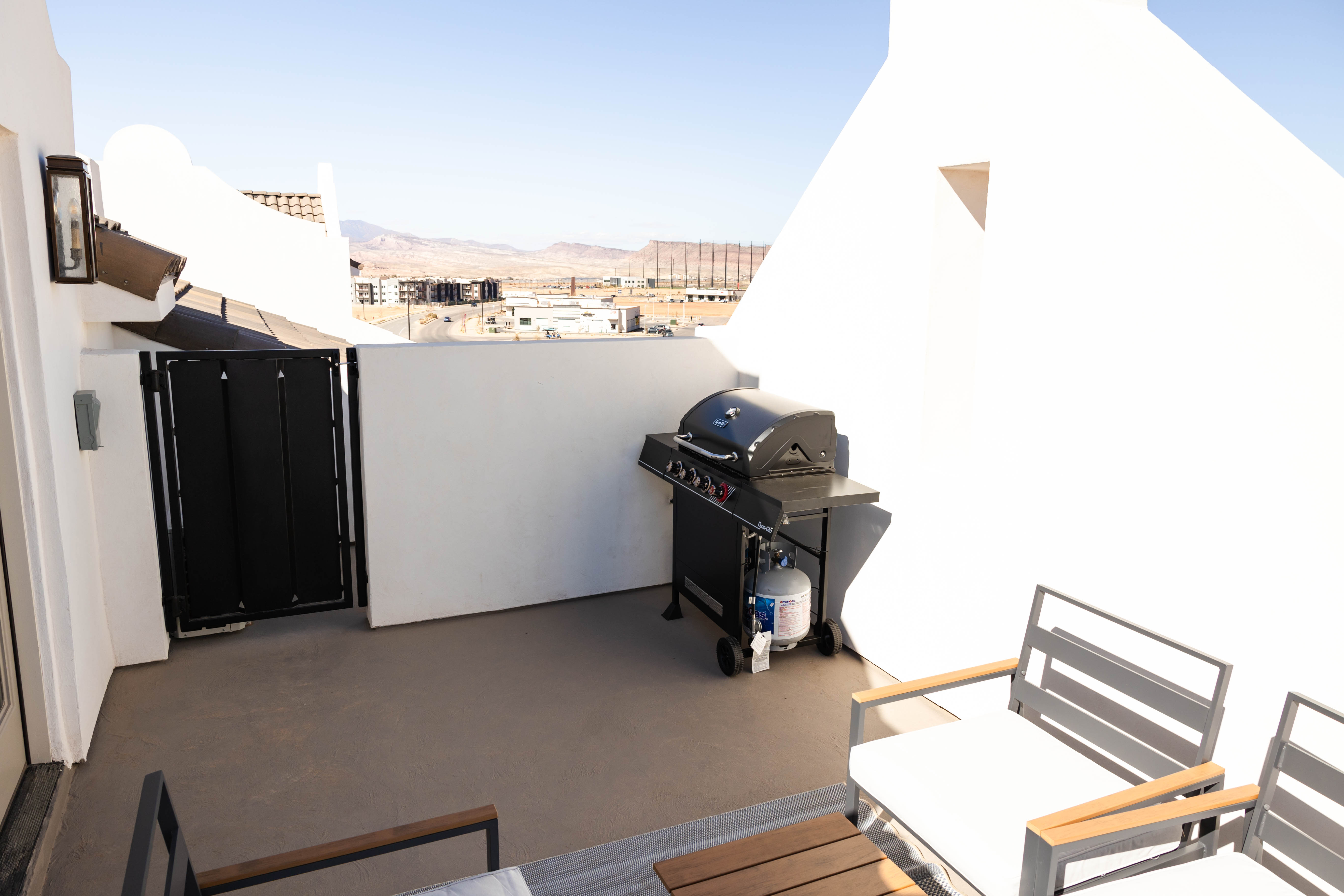 Spacious rooftop patio featuring light-toned flooring, high perimeter walls, and a prominent mountain backdrop