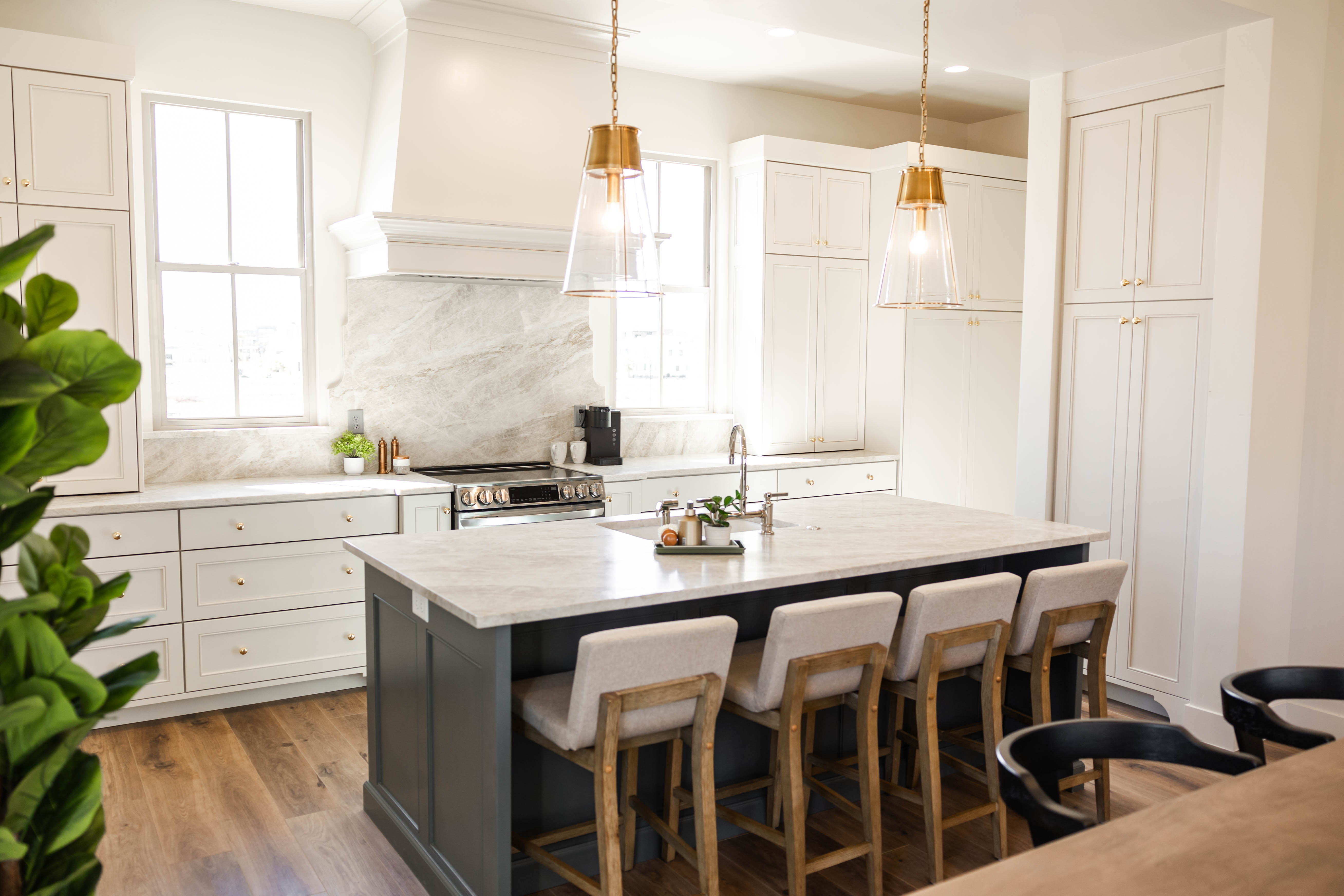Kitchen featuring a large island with seating, pendant lighting, shaker-style cabinetry, stainless steel appliances, and wood-finish flooring