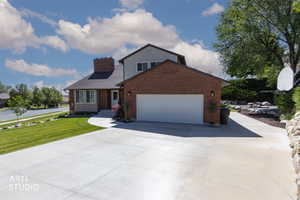 Brick and siding exterior with an attached garage, featuring a concrete driveway and walkway