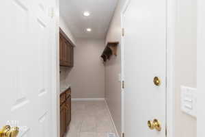 Utility area featuring wood cabinetry, a light-toned countertop, and recessed lighting