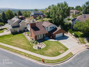 Multi-level residence featuring a brick and siding exterior, an attached garage, and a concrete driveway