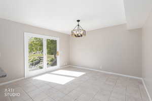 Ceramic tile flooring, neutral wall tones, and a contemporary chandelier