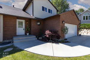 Brick exterior featuring white siding accents and a contrasting dark shingle roof