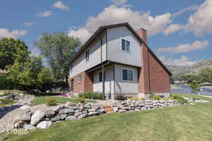 Two-story property featuring light-colored siding and brick accents