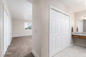 Bathroom featuring tile flooring, a granite-finish countertop, and wood-finish cabinetry