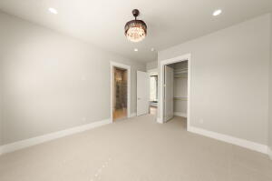 Carpeted room featuring a decorative ceiling light fixture, recessed lighting, and a closet with bifold doors