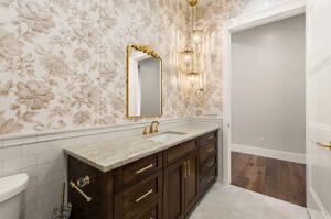 Vanity with brass hardware, undermount sink, and light-toned countertop