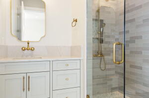 Bathroom vanity with white cabinetry and gold-tone hardware