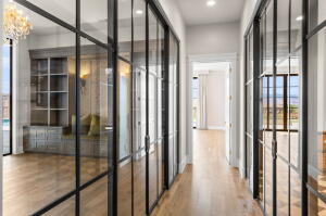 Hallway featuring expansive glass panel doors with black framing