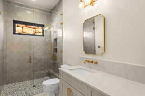 Single vanity with a white countertop and gold-toned fixtures