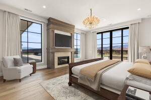 Spacious room featuring wood-finish flooring, a built-in fireplace with a stone surround, and large windows