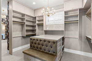 Custom closet system featuring extensive shelving, hanging rods, and built-in cabinetry