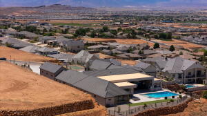 Residential property featuring a swimming pool with a surrounding patio, a covered outdoor area, and established landscaping