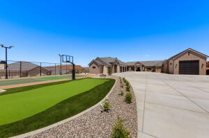 Expansive concrete driveway leading to a multi-car garage and a single-story residence