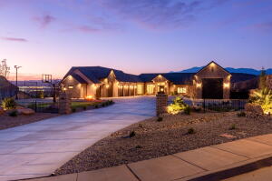 Expansive concrete driveway leading to a multi-car garage residence with stone accents