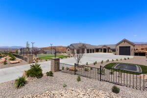 Expansive concrete driveway with brick columns and wrought iron fencing