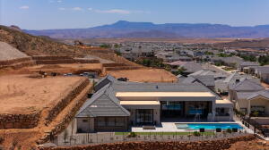 Modern residence featuring a dark gray roof, stucco exterior, and an integrated swimming pool with a spa