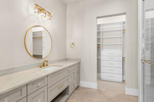Vanity with built-in cabinetry, an undermount sink, and a circular mirror
