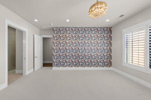 Spacious room featuring a patterned accent wall, recessed lighting, and a decorative ceiling fixture