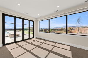 Spacious room featuring broad windows and multi-panel glass doors, offering expansive landscape views