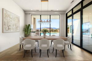Dining area featuring wood-finish flooring, a contemporary chandelier, recessed ceiling lighting, and expansive glass sliding doors