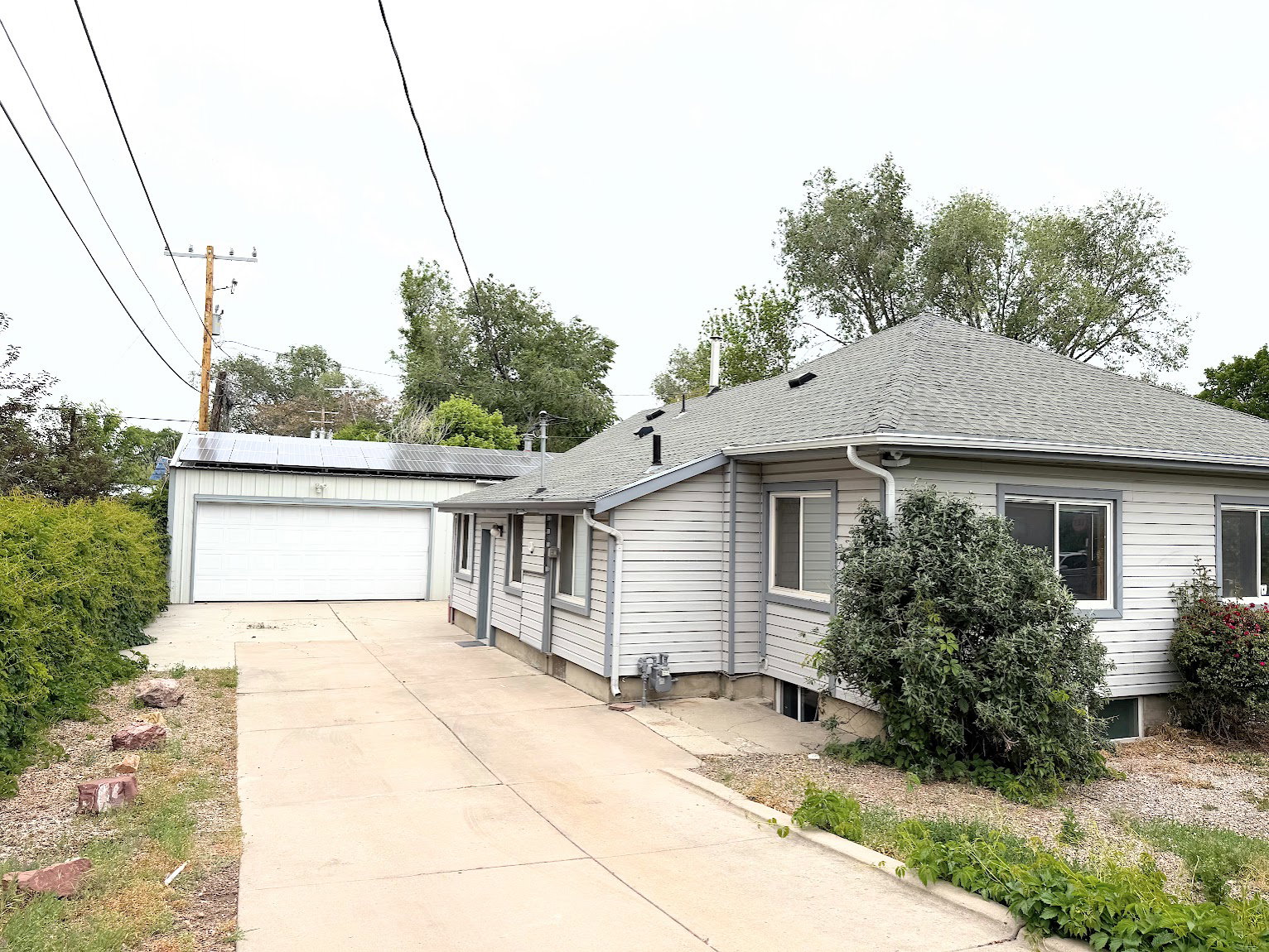Single-story residence featuring light gray horizontal siding and a gabled roof