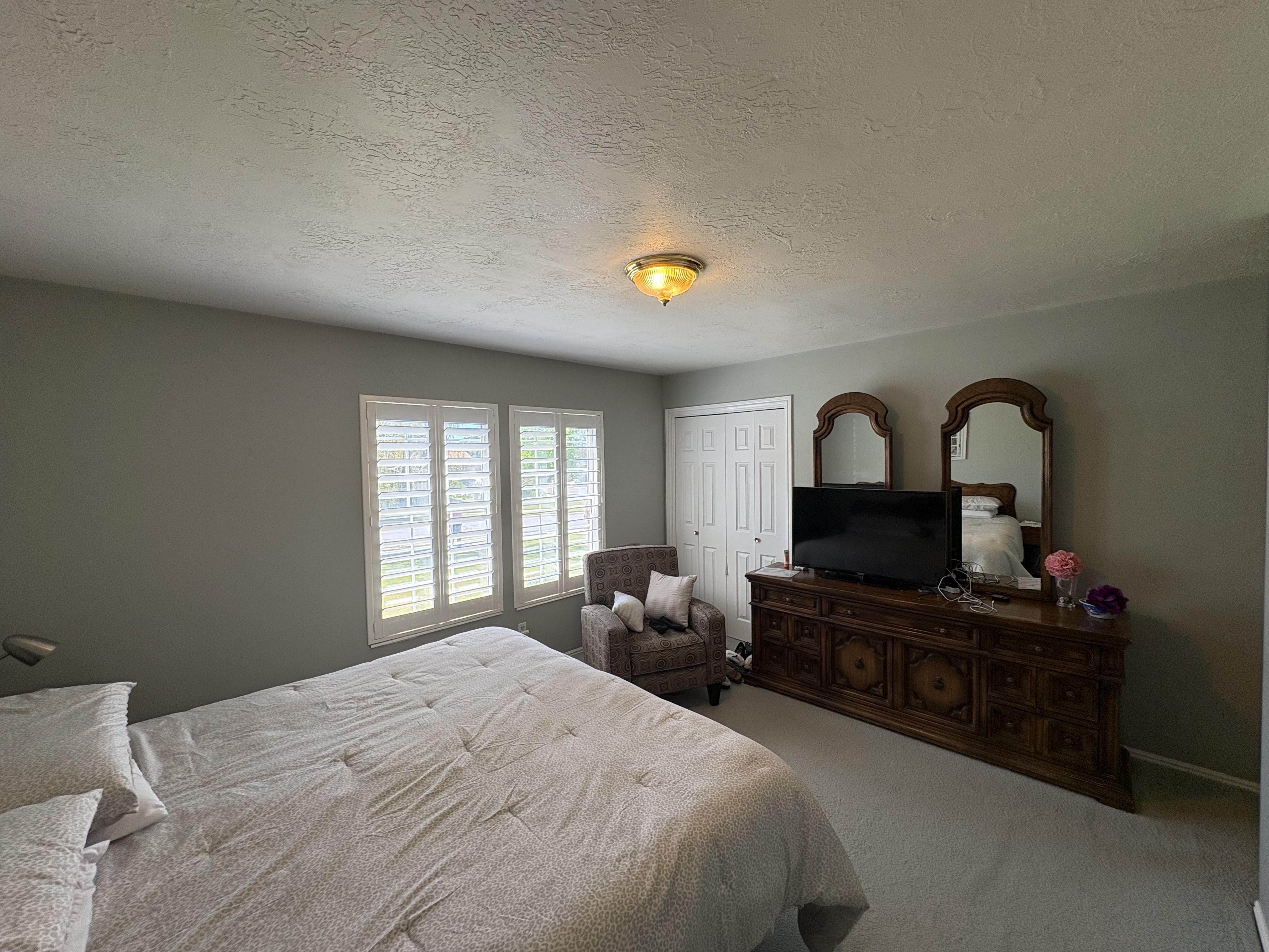 Bedroom featuring light gray walls, textured ceiling, and neutral carpet flooring