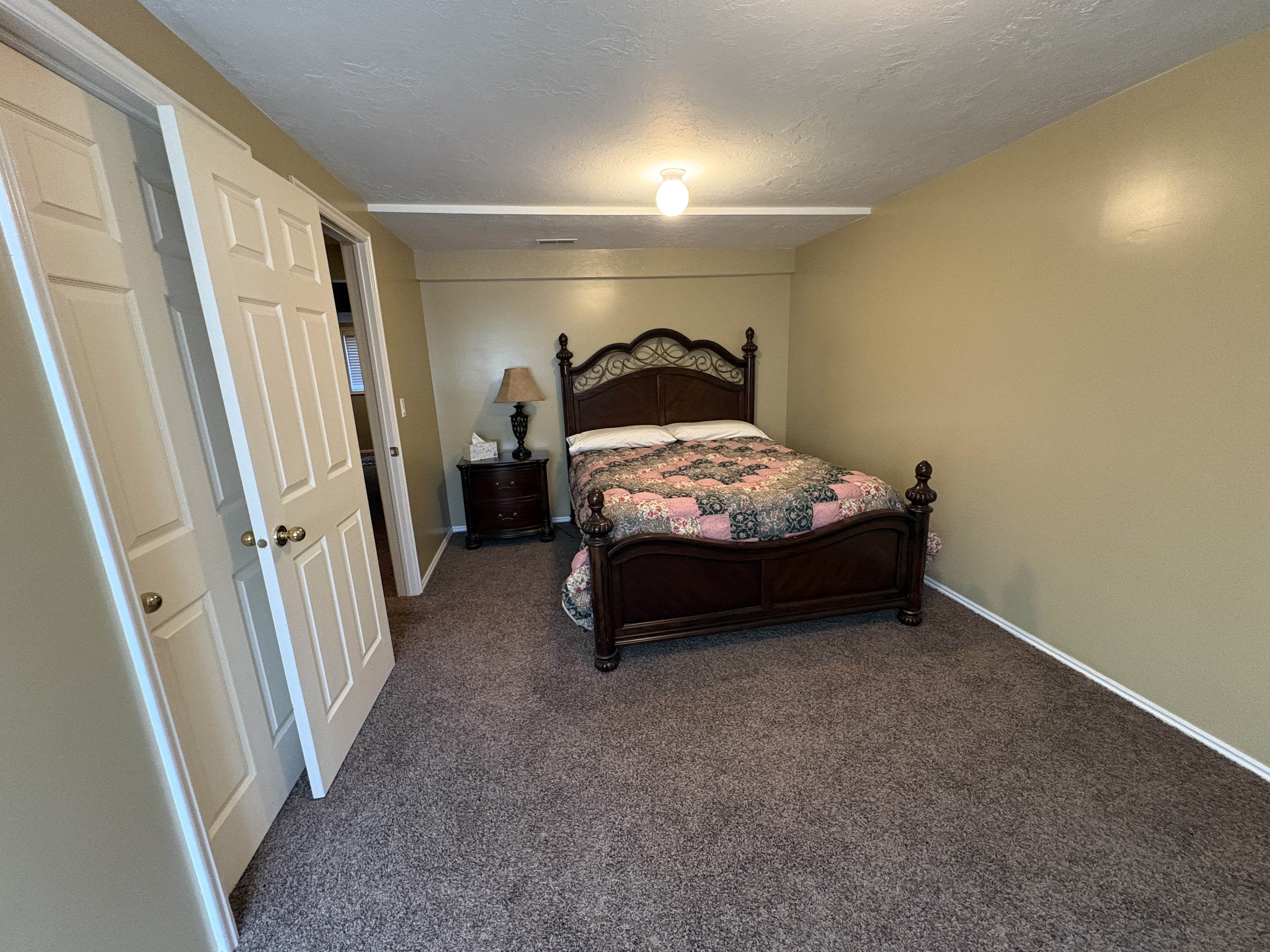 Carpeted interior room featuring neutral wall tones, white baseboards, and a semi-flush mount ceiling light