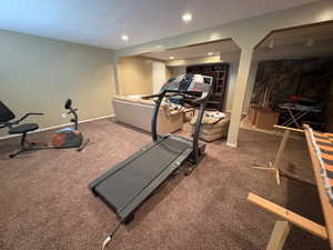 Expansive carpeted room featuring recessed lighting and a stone accent wall