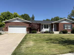 Brick facade home featuring a two-car garage, white garage door, and a concrete driveway