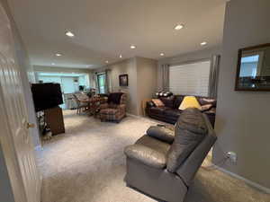 Expansive open-concept living area featuring recessed lighting, neutral wall tones, and carpet flooring