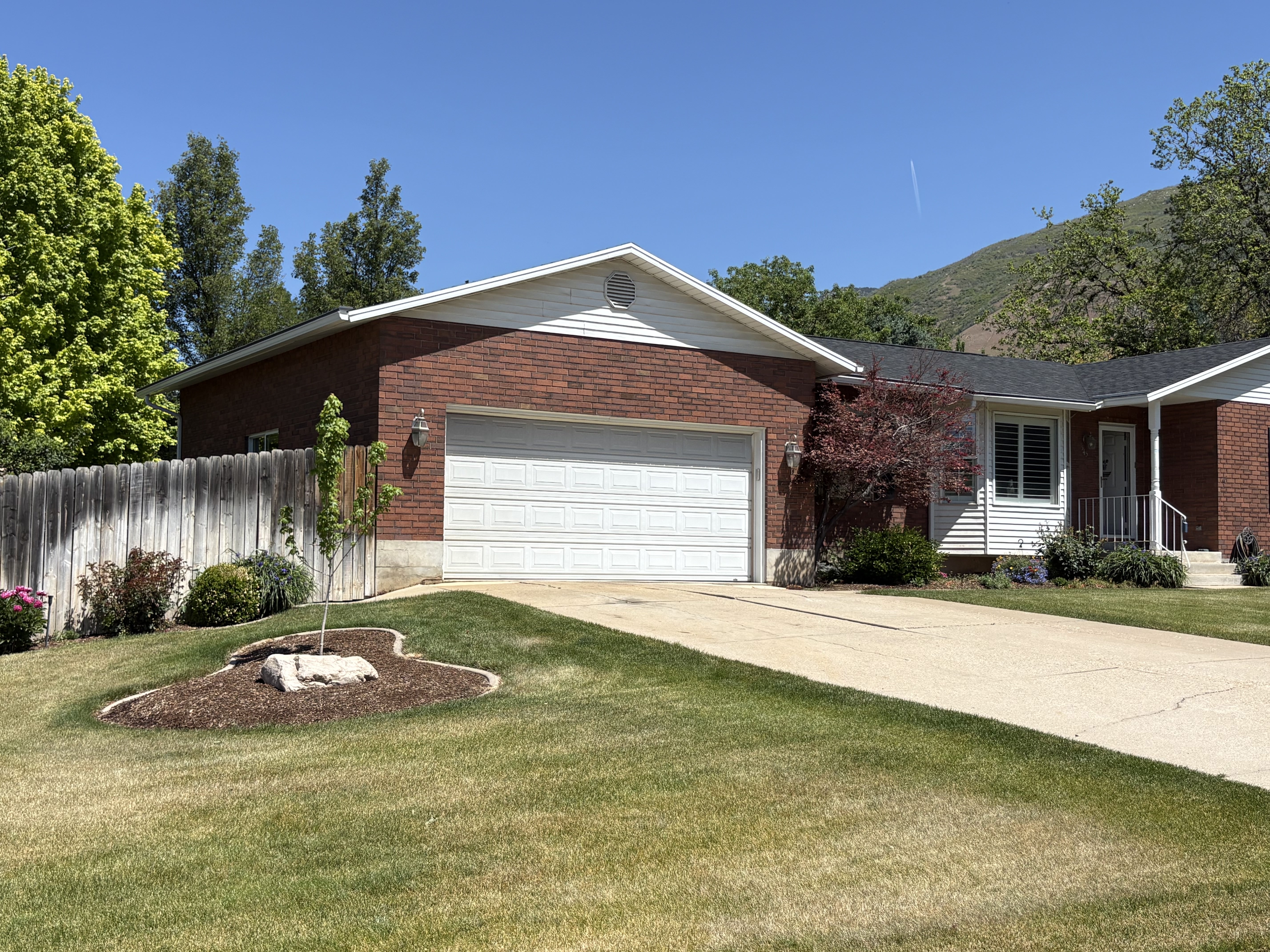 Red brick and white siding exterior with a two-car garage