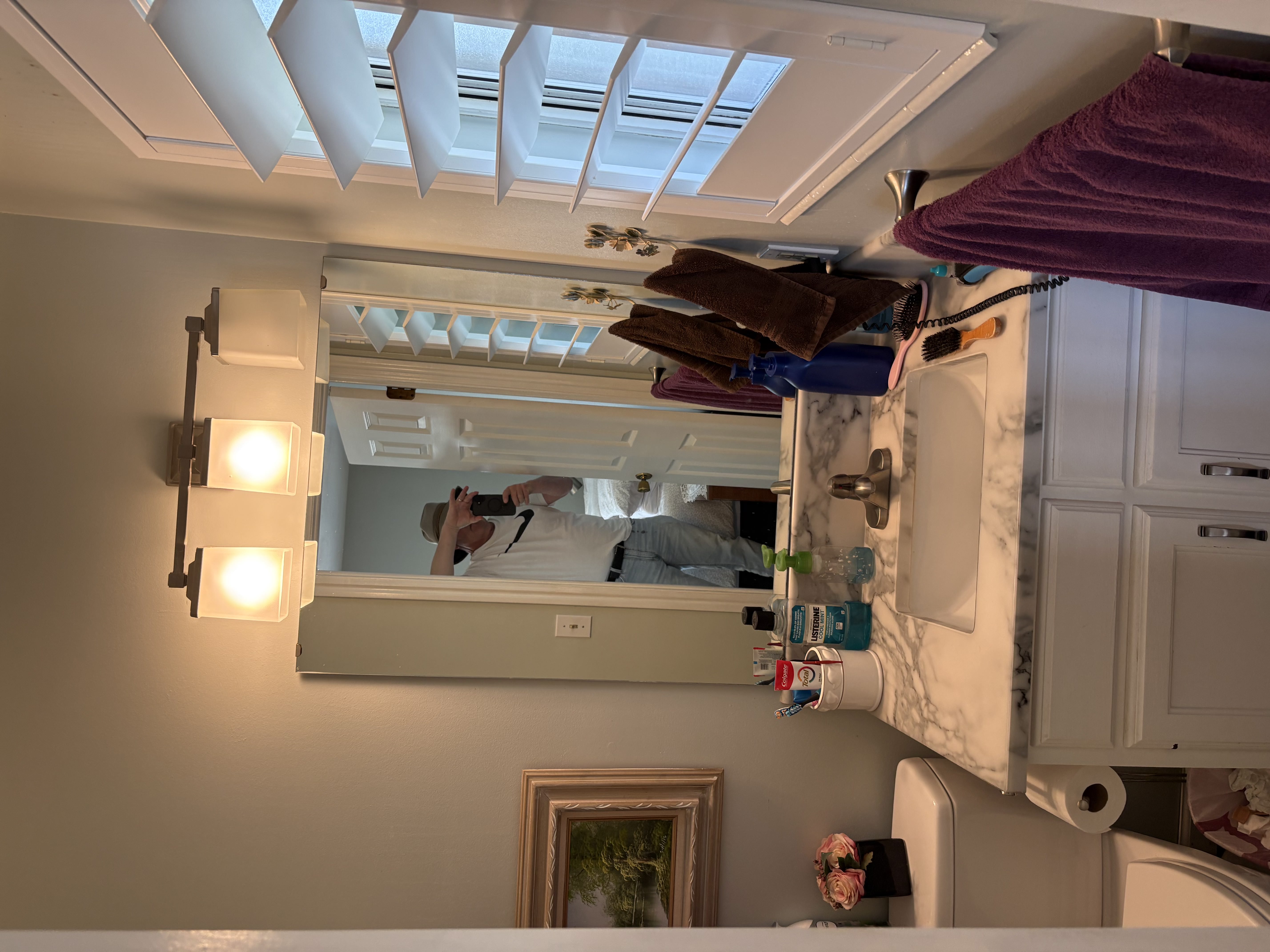 Bathroom vanity with a rectangular undermount sink, marble-finish countertop, and white cabinetry featuring brushed nickel hardware