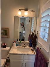 Bathroom vanity with a rectangular undermount sink, marble-finish countertop, and white cabinetry featuring brushed nickel hardware