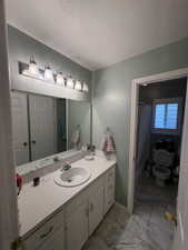 Bathroom vanity featuring a single-basin sink, white countertop, and white cabinetry