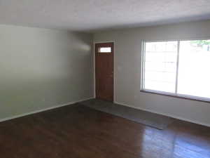 Spacious interior with wood-finish flooring, light-toned walls, and a large multi-pane window
