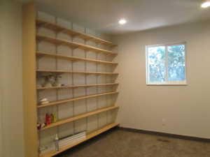 Extensive wall-mounted shelving unit with light wood-finish shelves