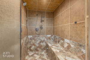 Tiled shower with a mosaic herringbone floor and built-in bench
