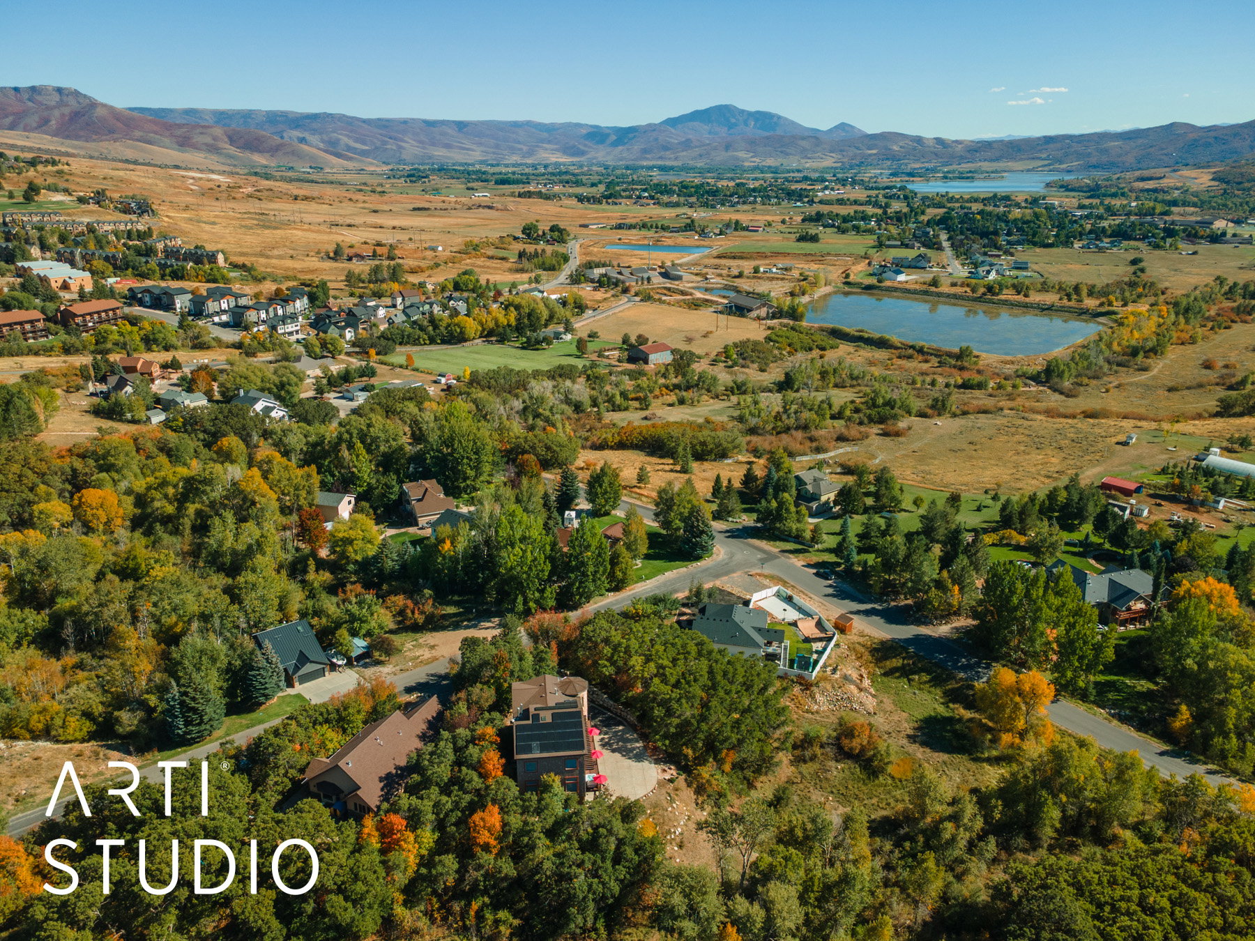 Aerial perspective showcasing a residential area with varied architecture, surrounded by extensive natural landscaping