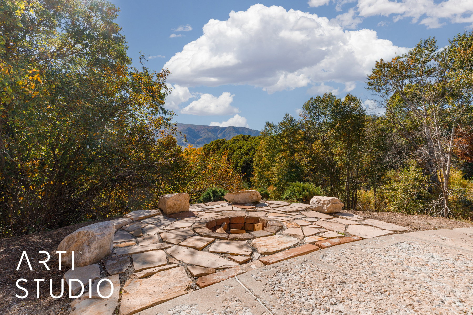 Outdoor flagstone patio featuring a built-in fire pit with brick interior and stone surround