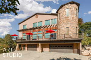 Multi-level stucco exterior with a prominent stone-clad turret